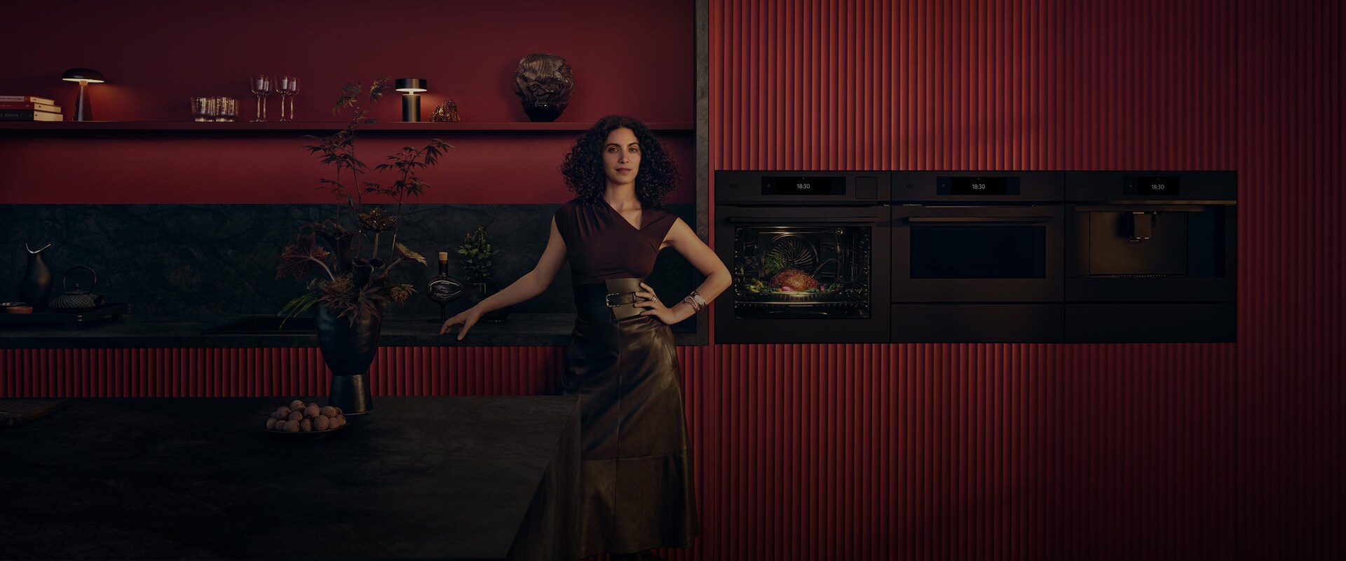 En kvinde står foran en ovn.